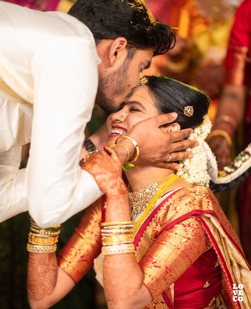  tender pose where the groom kisses the bride's forehead, symbolizing respect and affection