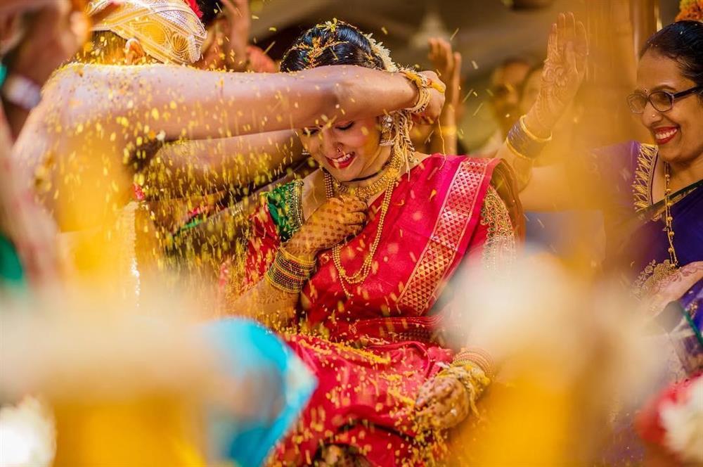 Capturing the sacred moment during the Mangalashtak, with the couple's expressions as they are showered with rice